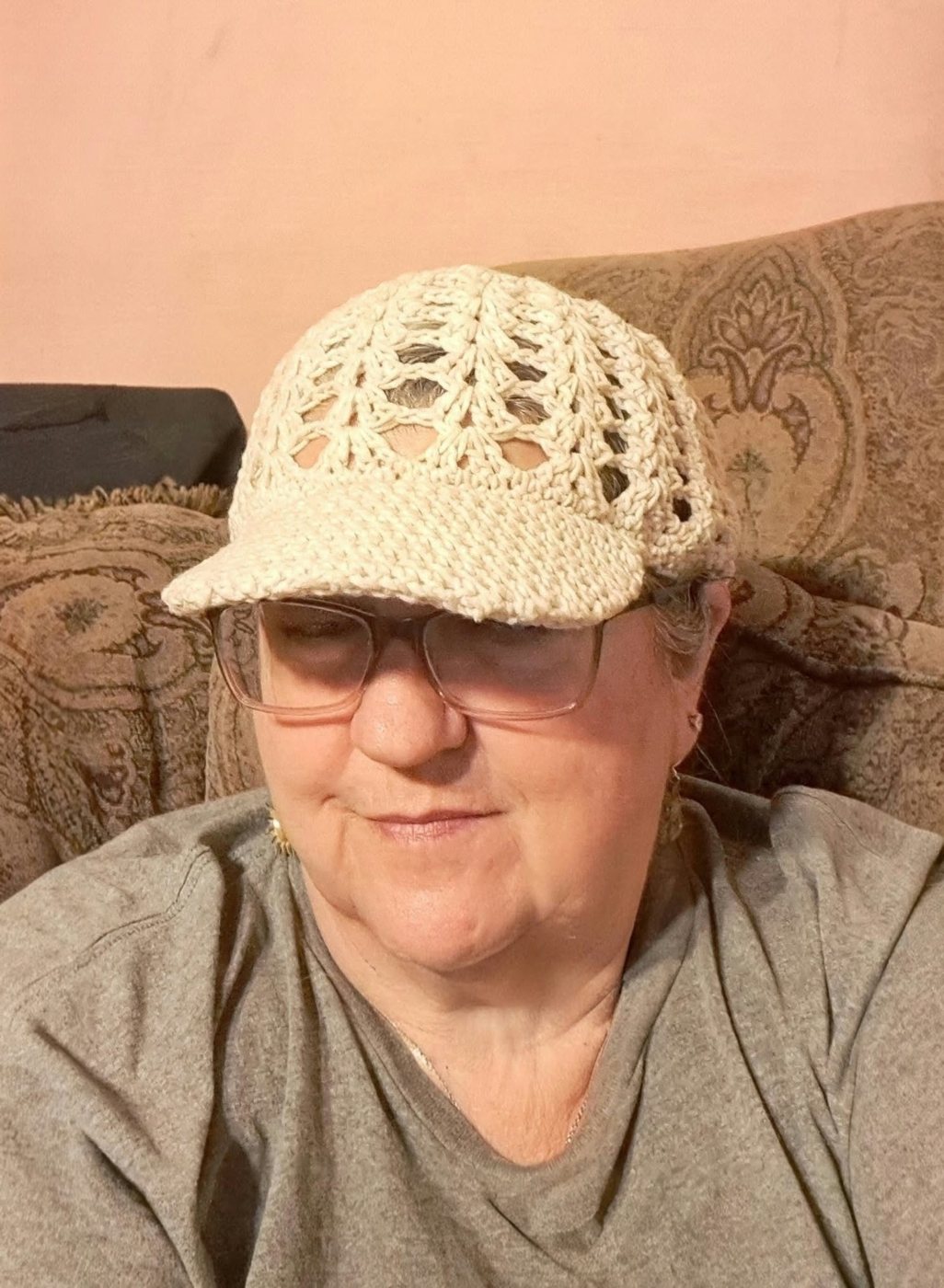 Jennifer wearing a cream crochet sun hat with a brim